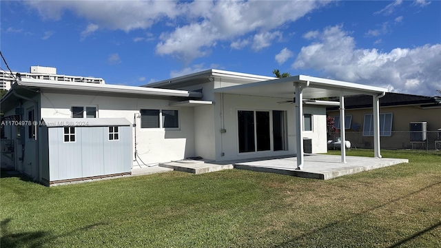 rear view of property with a lawn, ceiling fan, and a patio area