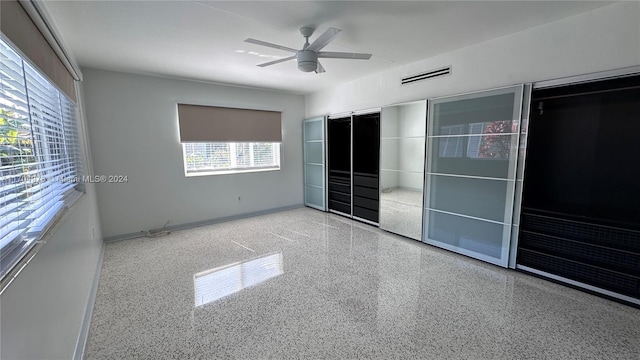 unfurnished bedroom featuring ceiling fan and multiple windows