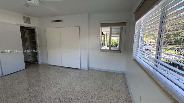 unfurnished bedroom featuring ceiling fan and a closet