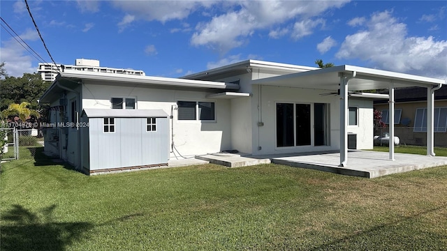 back of property featuring a lawn and ceiling fan