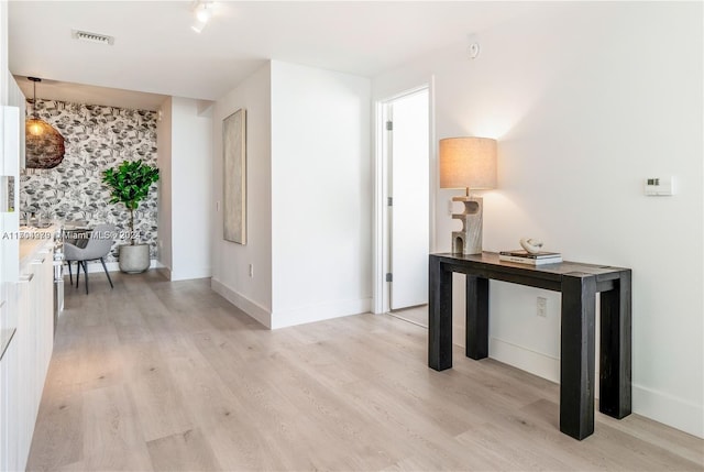 corridor with light hardwood / wood-style floors