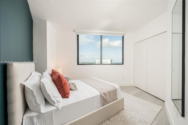 bedroom with light hardwood / wood-style flooring and a closet