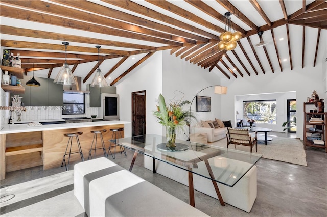 living room featuring lofted ceiling with beams, sink, and an inviting chandelier