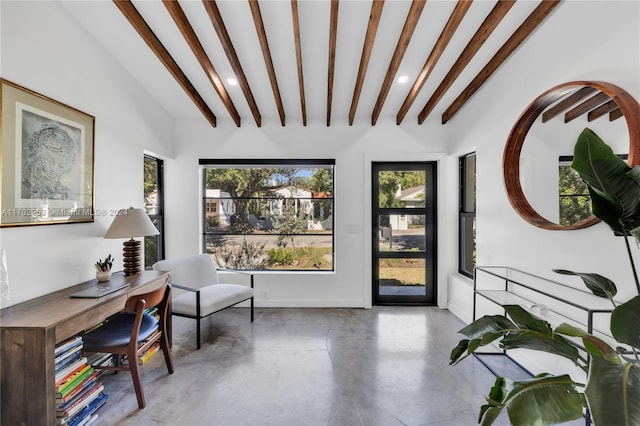 sitting room featuring beamed ceiling and concrete flooring