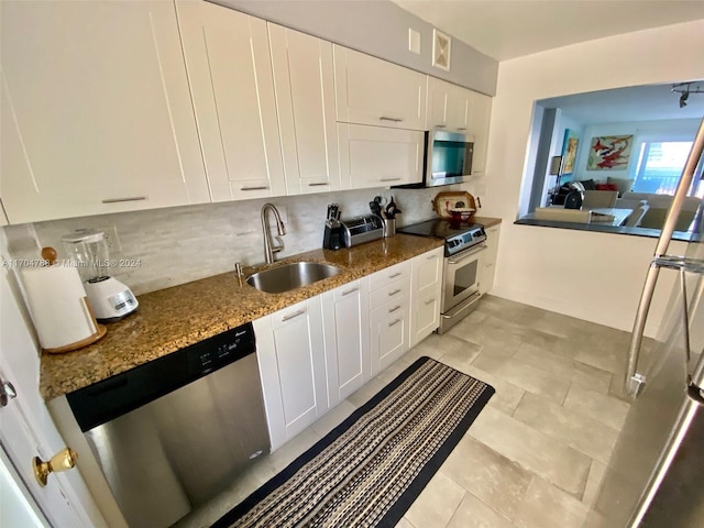 kitchen with dark stone countertops, white cabinetry, sink, and appliances with stainless steel finishes