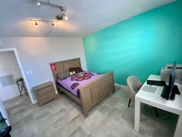 bedroom with lofted ceiling and a textured ceiling