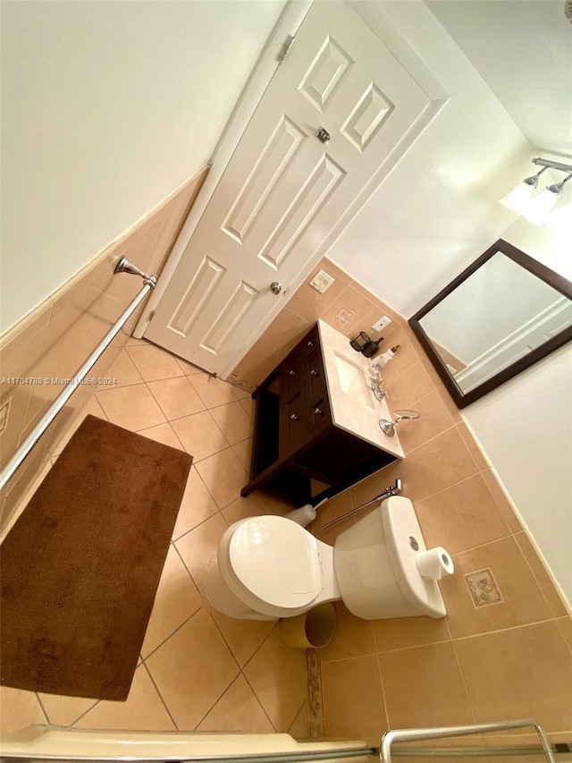 bathroom with tile patterned flooring, toilet, and tile walls