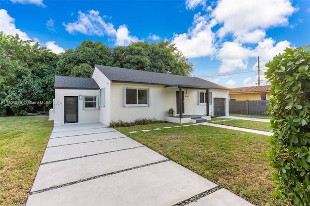 ranch-style house featuring a front yard and a garage