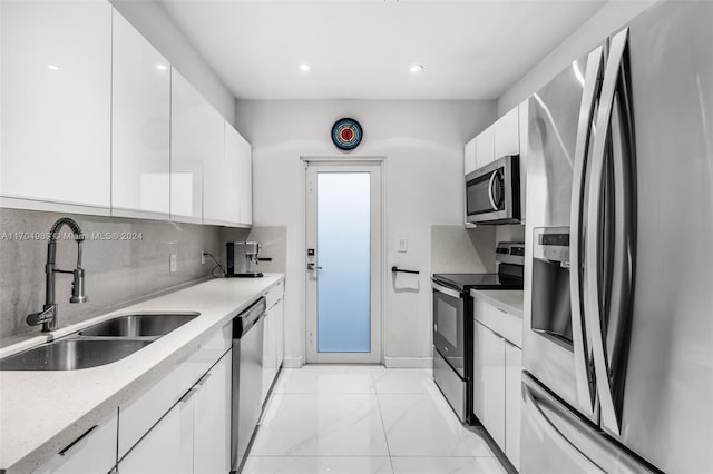 kitchen with appliances with stainless steel finishes, backsplash, white cabinetry, and sink