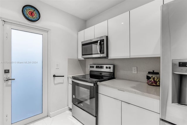 kitchen with white cabinetry, light tile patterned floors, and appliances with stainless steel finishes