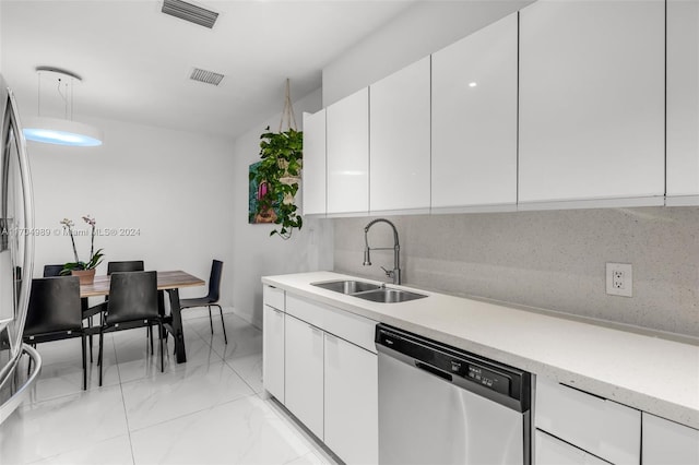 kitchen featuring dishwasher, backsplash, white cabinetry, and sink