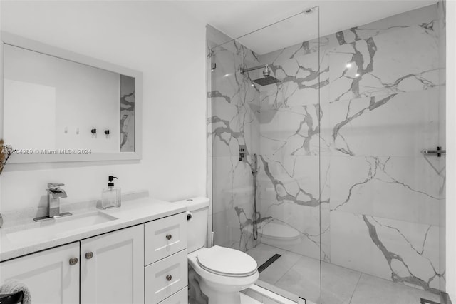 bathroom with vanity, toilet, and a tile shower