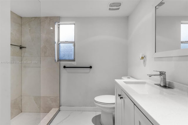 bathroom featuring tiled shower, vanity, and toilet