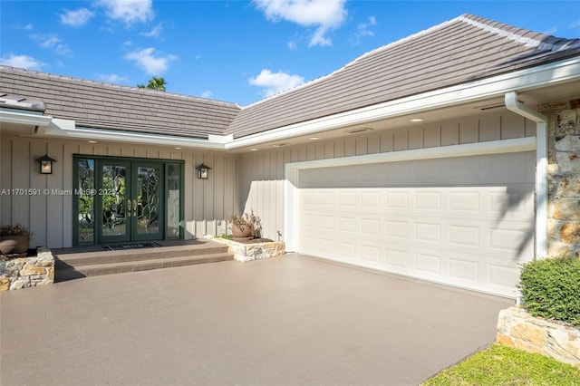 view of exterior entry featuring french doors and a garage