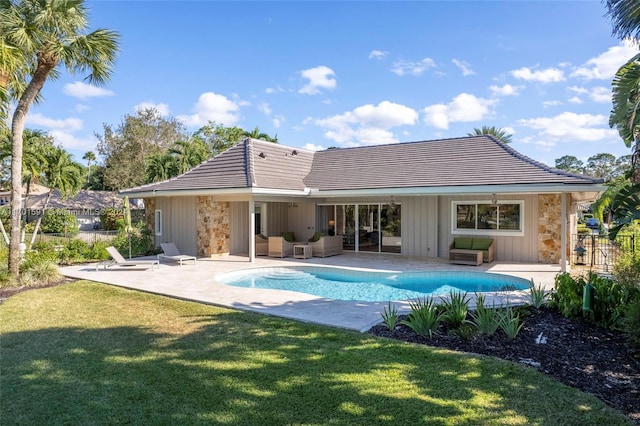 rear view of property featuring a lawn, an outdoor living space, and a patio