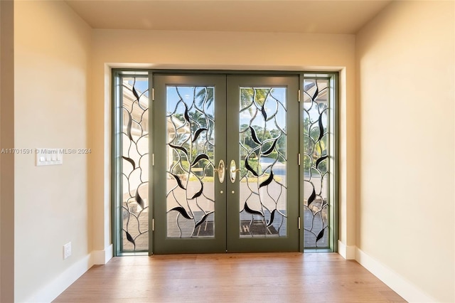 entryway with french doors and light hardwood / wood-style floors