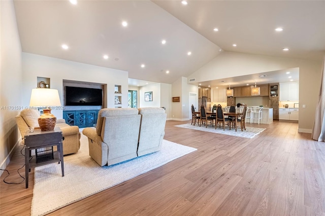 living room featuring high vaulted ceiling and light wood-type flooring