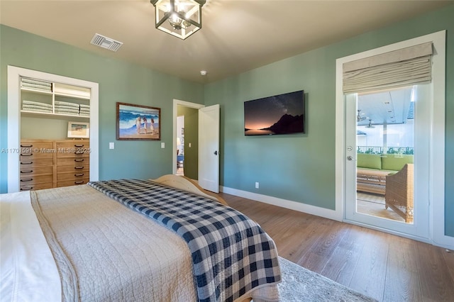 bedroom with hardwood / wood-style floors and access to outside