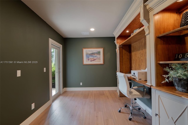 office with built in desk and light wood-type flooring