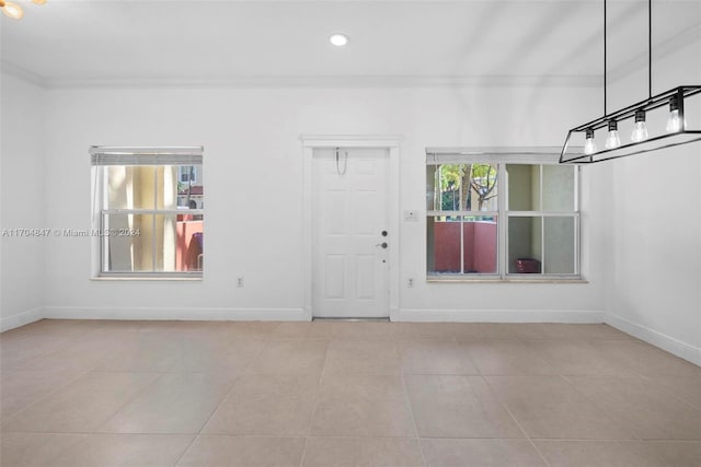 entrance foyer featuring light tile patterned flooring and crown molding