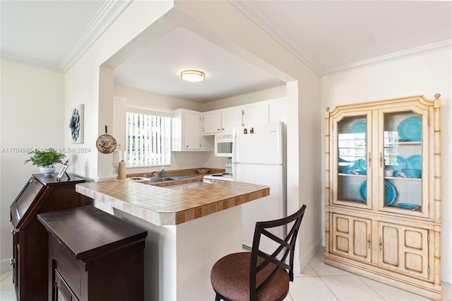 kitchen featuring white cabinets, kitchen peninsula, crown molding, white appliances, and light tile patterned floors