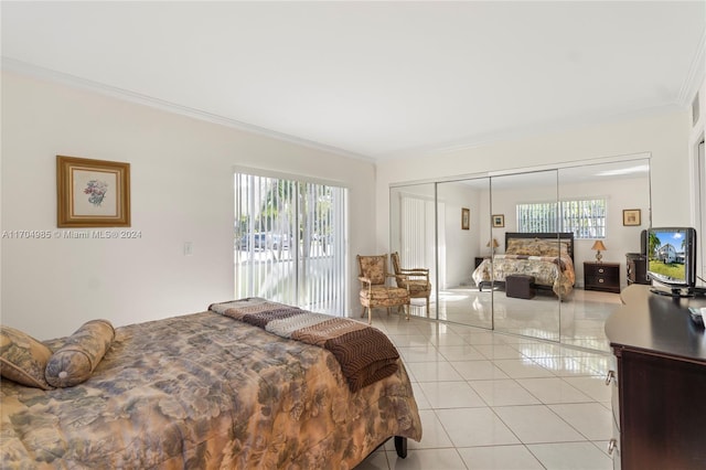 bedroom featuring ornamental molding, light tile patterned floors, and a closet