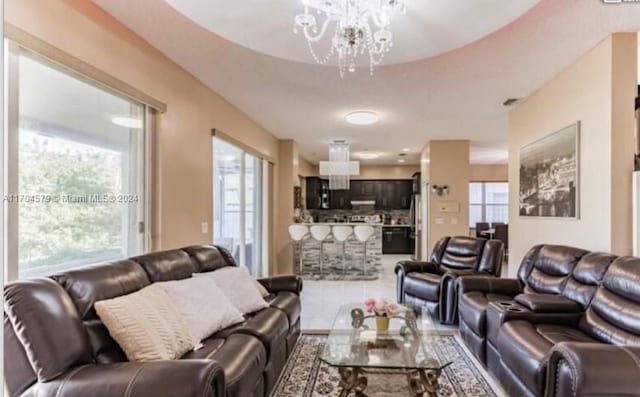 tiled living room with an inviting chandelier and a healthy amount of sunlight