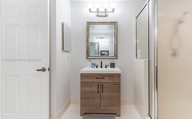 bathroom featuring tile patterned flooring, vanity, and a shower with shower door