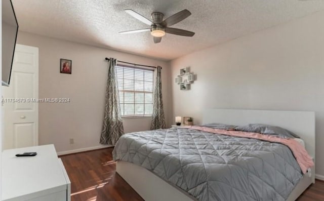 bedroom featuring ceiling fan, dark wood-type flooring, and a textured ceiling