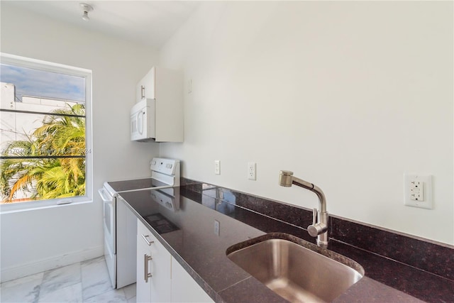 kitchen with sink, white cabinets, dark stone counters, and white appliances