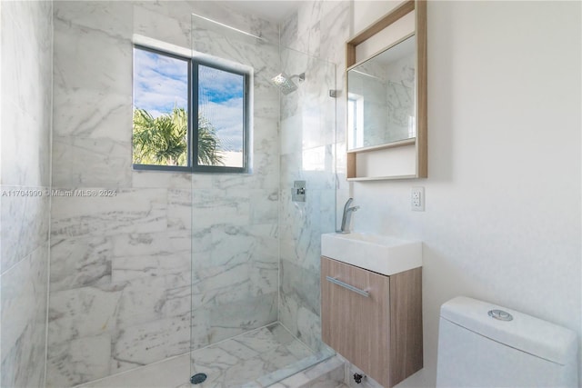 bathroom featuring vanity, toilet, and a tile shower