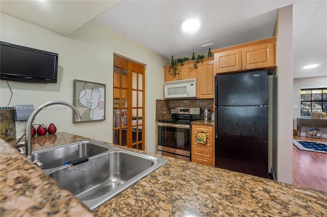 kitchen featuring black refrigerator, light brown cabinetry, sink, electric stove, and hardwood / wood-style floors