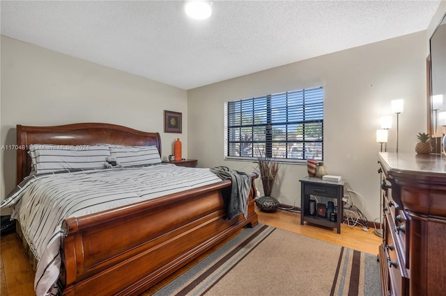 bedroom with wood-type flooring and a textured ceiling