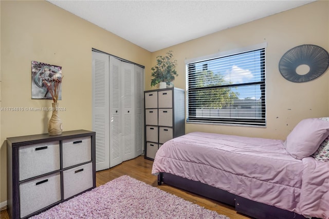 bedroom featuring light hardwood / wood-style floors, a textured ceiling, and a closet