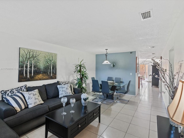 tiled living room featuring a textured ceiling