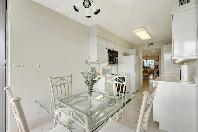 dining space with light tile patterned floors and a chandelier