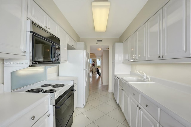 kitchen featuring sink, white electric stove, dishwasher, white cabinetry, and light tile patterned flooring