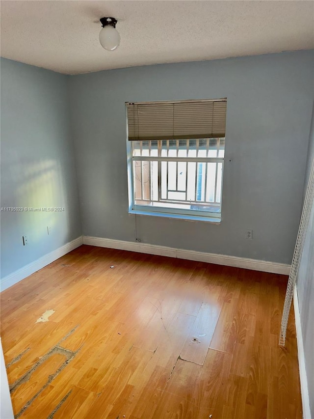 empty room featuring a textured ceiling and hardwood / wood-style flooring