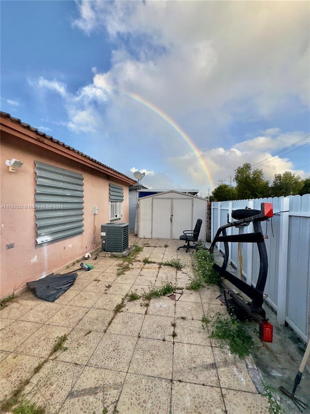 view of patio / terrace featuring central air condition unit and a storage shed