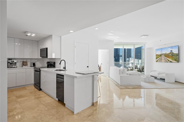 kitchen featuring kitchen peninsula, backsplash, sink, black appliances, and white cabinetry