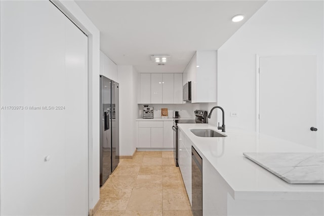 kitchen featuring white cabinets, sink, light tile patterned floors, and stainless steel appliances