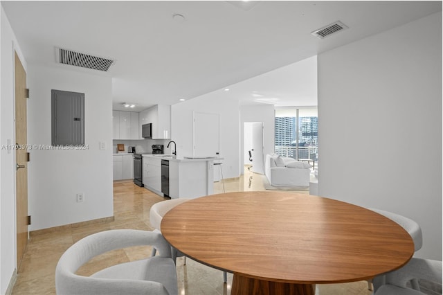 tiled dining space featuring electric panel and sink