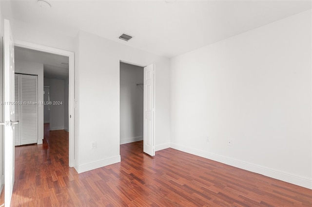 unfurnished bedroom featuring dark hardwood / wood-style floors and a closet