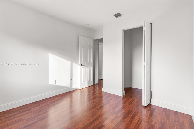 unfurnished bedroom with dark wood-type flooring and a closet