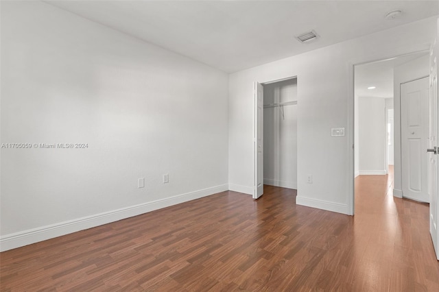 unfurnished bedroom with a closet and dark hardwood / wood-style flooring