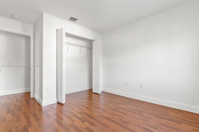 unfurnished bedroom featuring a closet and dark wood-type flooring