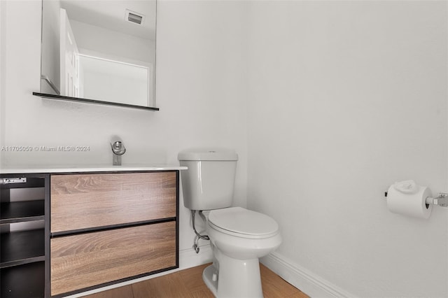 bathroom featuring vanity, wood-type flooring, and toilet