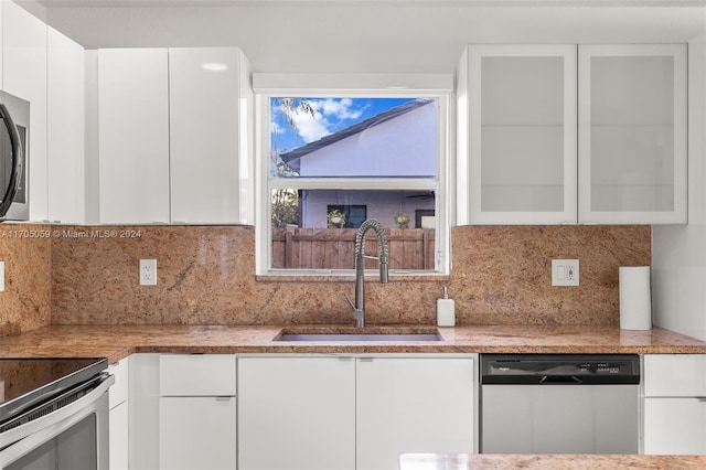 kitchen with decorative backsplash, appliances with stainless steel finishes, white cabinetry, and sink