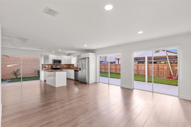 unfurnished living room with plenty of natural light and light hardwood / wood-style floors