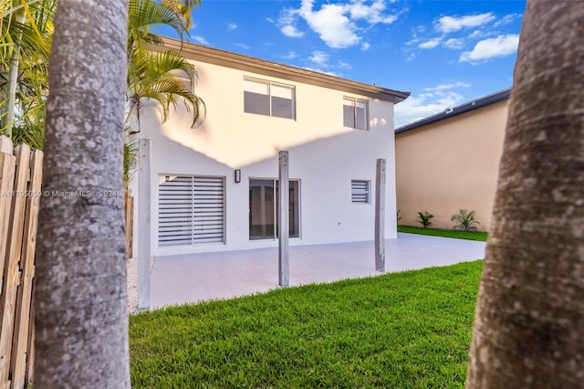 back of house featuring a yard and a patio area